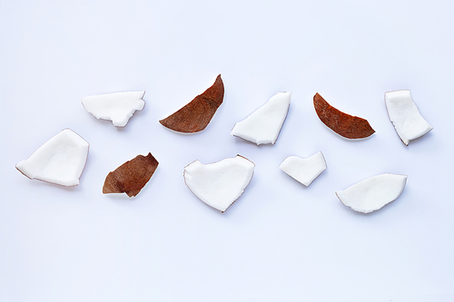 Coconut pieces on white background. Top view of tropical fruit.