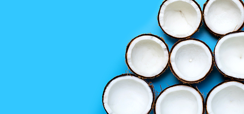 Half coconuts on blue background. Top view