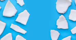 Coconut cut pieces on blue background. Copy space