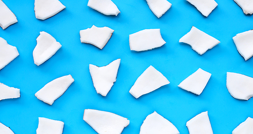 Coconut cut pieces on blue background. Top view