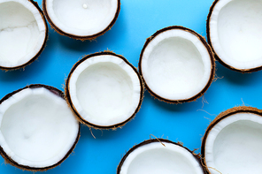 Half coconuts on blue background. Top view