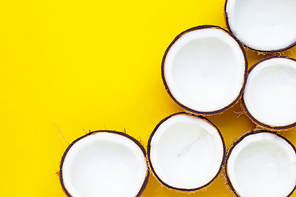 Half coconuts on yellow background. Copy space