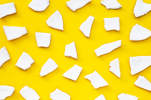 Coconut cut pieces on yellow background. Top view