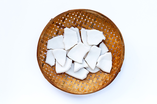 Coconut pieces on wooden bamboo threshing basket on white background.