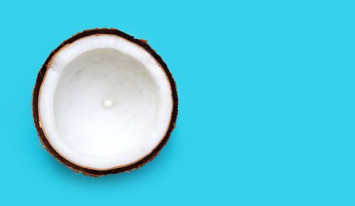 Half Coconut on blue background. Copy space