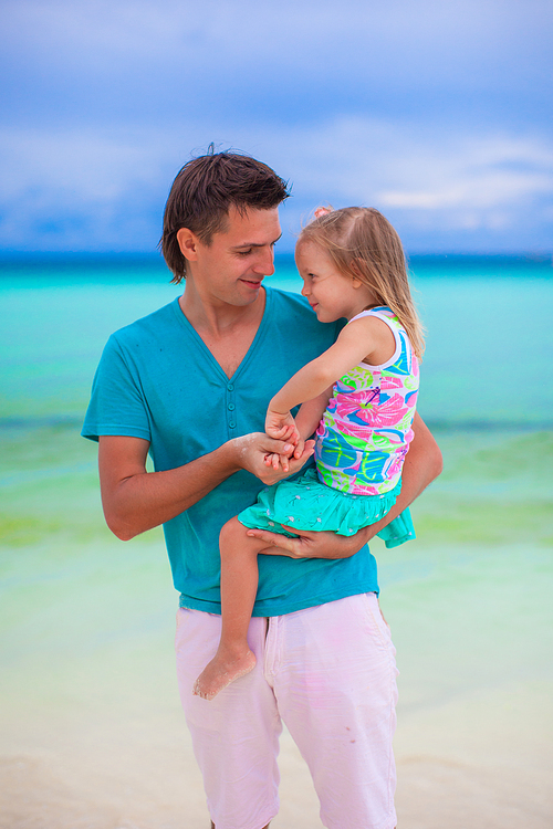Happy father and his adorable little daughter at white sandy beach
