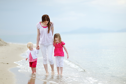 Mother and her two girls walking along a beach