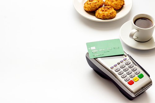 Payment transactions. Terminal and credit card on cafe white table.