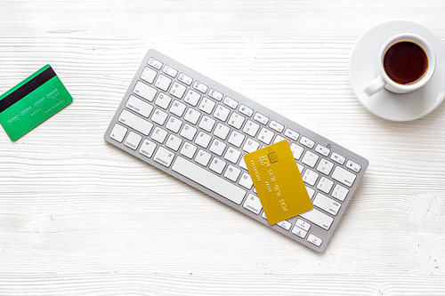 shopping online payment. Card on keyboard on white desk top-down.