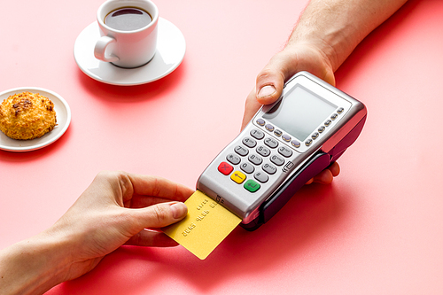 Payment transactions. Hand hold card near terminal on cafe table