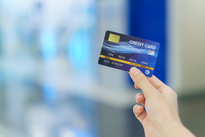 Woman holding credit card for shopping at department store with bokeh Background.