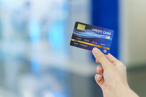 Woman holding credit card for shopping at department store with bokeh Background.
