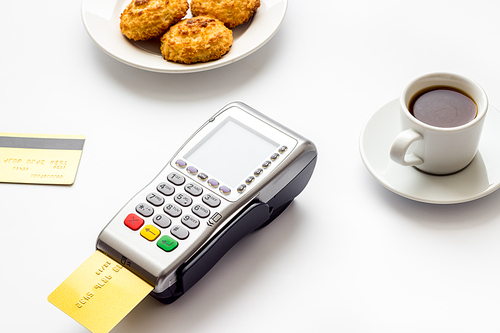 Payment transactions. Terminal and credit card on cafe white table.