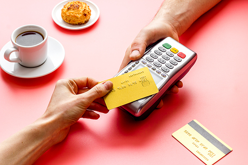 Payment transactions. Hand hold card near terminal on cafe table