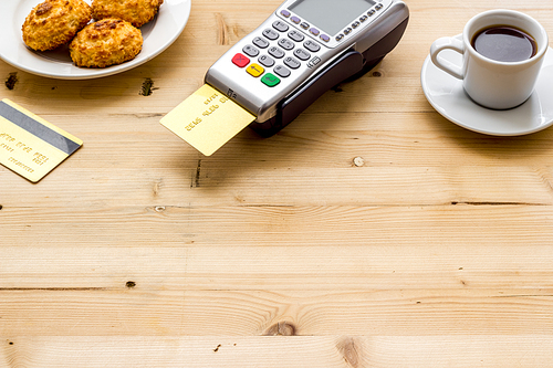 Payment transactions. Terminal and credit card on cafe wooden table.