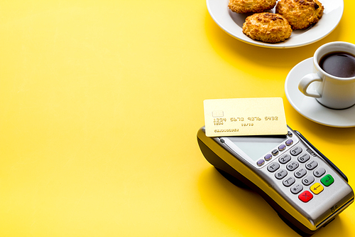 Payment transactions. Terminal and credit card on cafe wooden table.