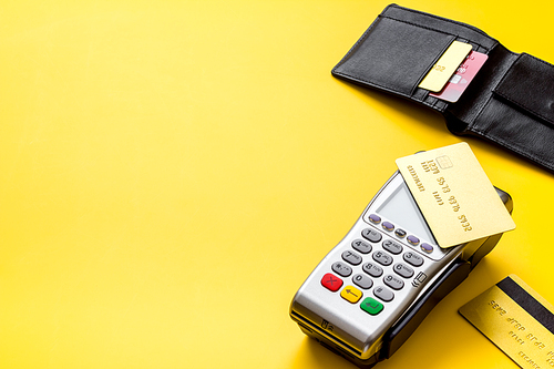Payment by credit card. Terminal on yellow table.