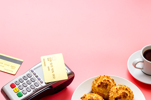 Payment transactions. Terminal and credit card on cafe pink table.