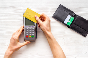 Payment by credit card. Hand hold card near terminal on desk top view