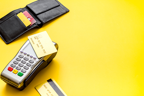 Payment by credit card. Terminal on yellow table.