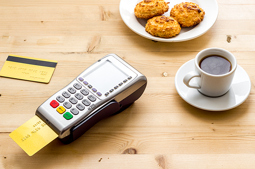 Payment transactions. Terminal and credit card on cafe wooden table.