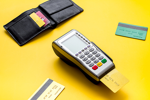 Payment by credit card. Terminal on yellow table.