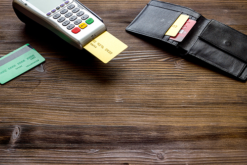 Payment by credit card. Terminal on wooden table.