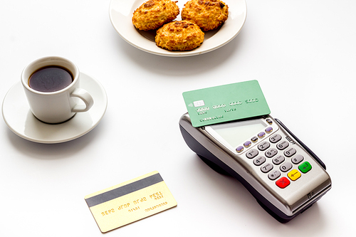 Payment transactions. Terminal and credit card on cafe white table.