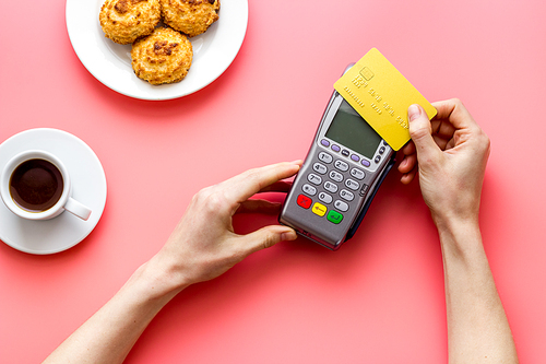 Payment by credit card. Hand hold card near terminal on desk top view