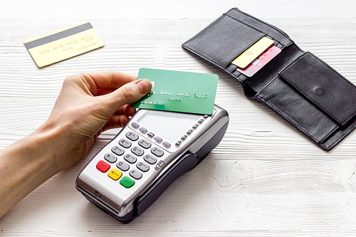 Payment by credit card. Hand hold card near terminal on table