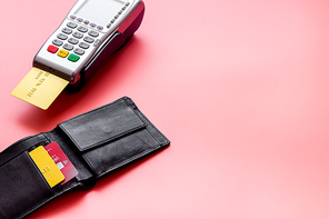 Payment by credit card. Terminal on pink table.