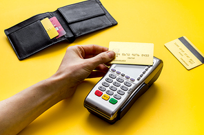 Payment by credit card. Hand hold card near terminal on table