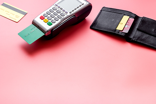 Payment by credit card. Terminal on pink table.