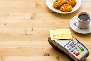 Payment transactions. Terminal and credit card on cafe wooden table.