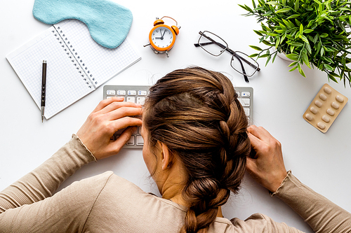 Tired woman sleeps on office desk top view.