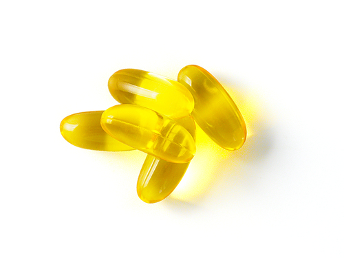 Omega 3 fish oil capsules isolated on white. Golden color capsules - vitamin E, D or multivitamin.