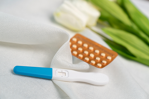 Pregnancy test and Birth control pill on white background. Concept for contraceptive