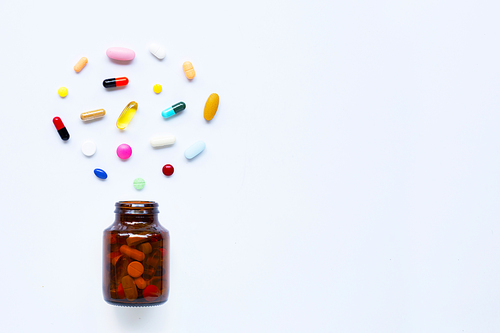 Colorful tablets with capsules and pills on white background. Copy space