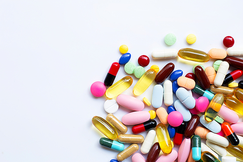 Colorful tablets with capsules and pills on white background.