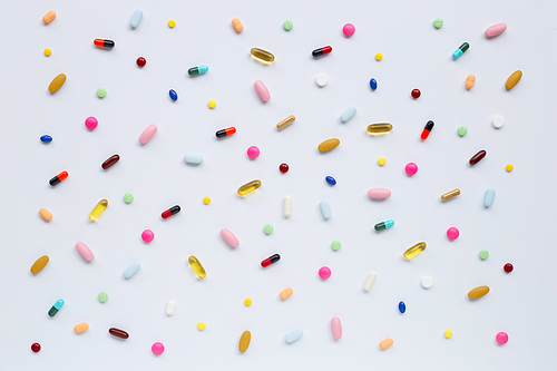 Colorful tablets with capsules and pills on white background.