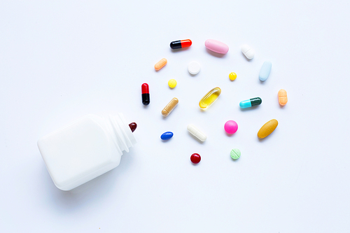 Colorful tablets with capsules and pills on white background.