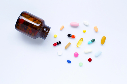 Colorful tablets with capsules and pills on white background.