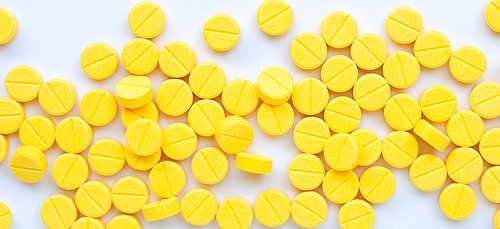 Yellow tablets of Paracetamol on white background. Top view