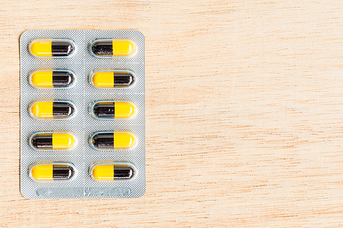 Pills in blister pack on wooden background