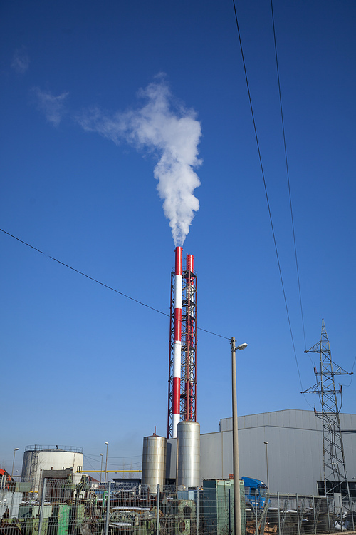 Heating plant - powerhouse and chimey with smoke make heat energy for city in winter