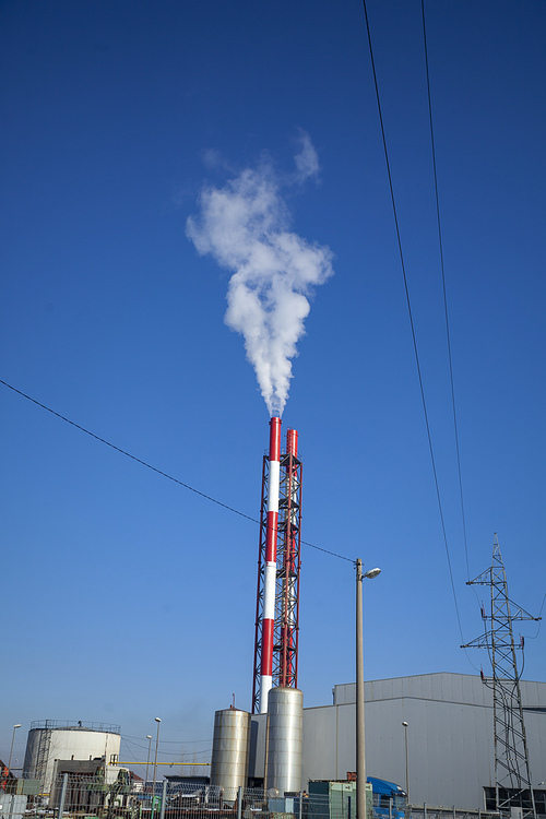 Heating plant - powerhouse and chimey with smoke make heat energy for city in winter