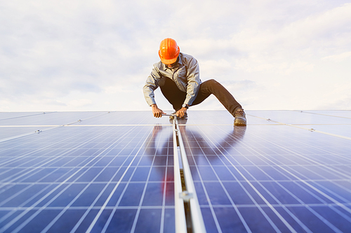 The young man is repairing the solar panel at the station.