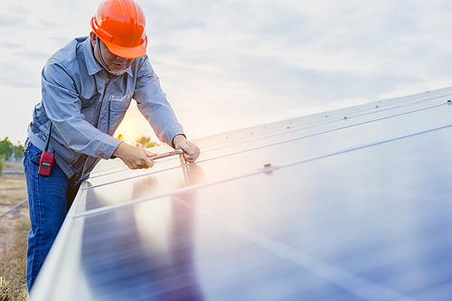 The young man is repairing the solar panel at the station.