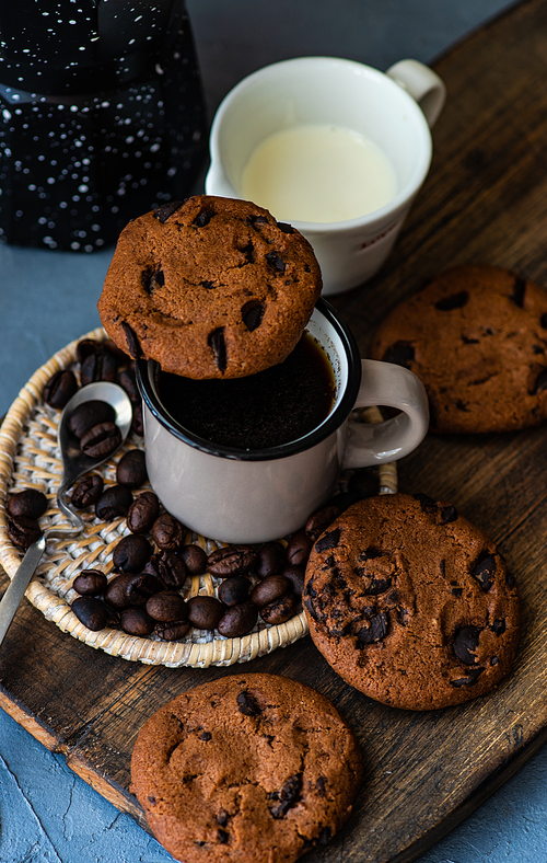Coffee time concept with cup of coffee and chocolate cookies on rustic background with copy space