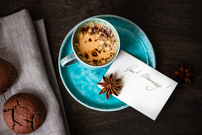 Cup of coffee and good morning note on wooden background with copy space